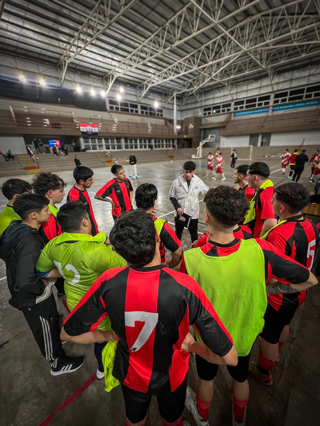 El plantel de Real Vasconia escucha la charla técnica junto a la cancha